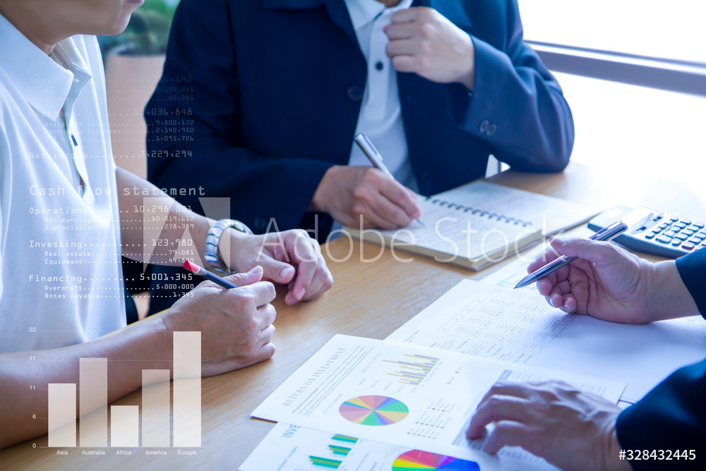 Business men in a meeting discuss and review financeial statements and reports on business performance and return on investment, ROI.